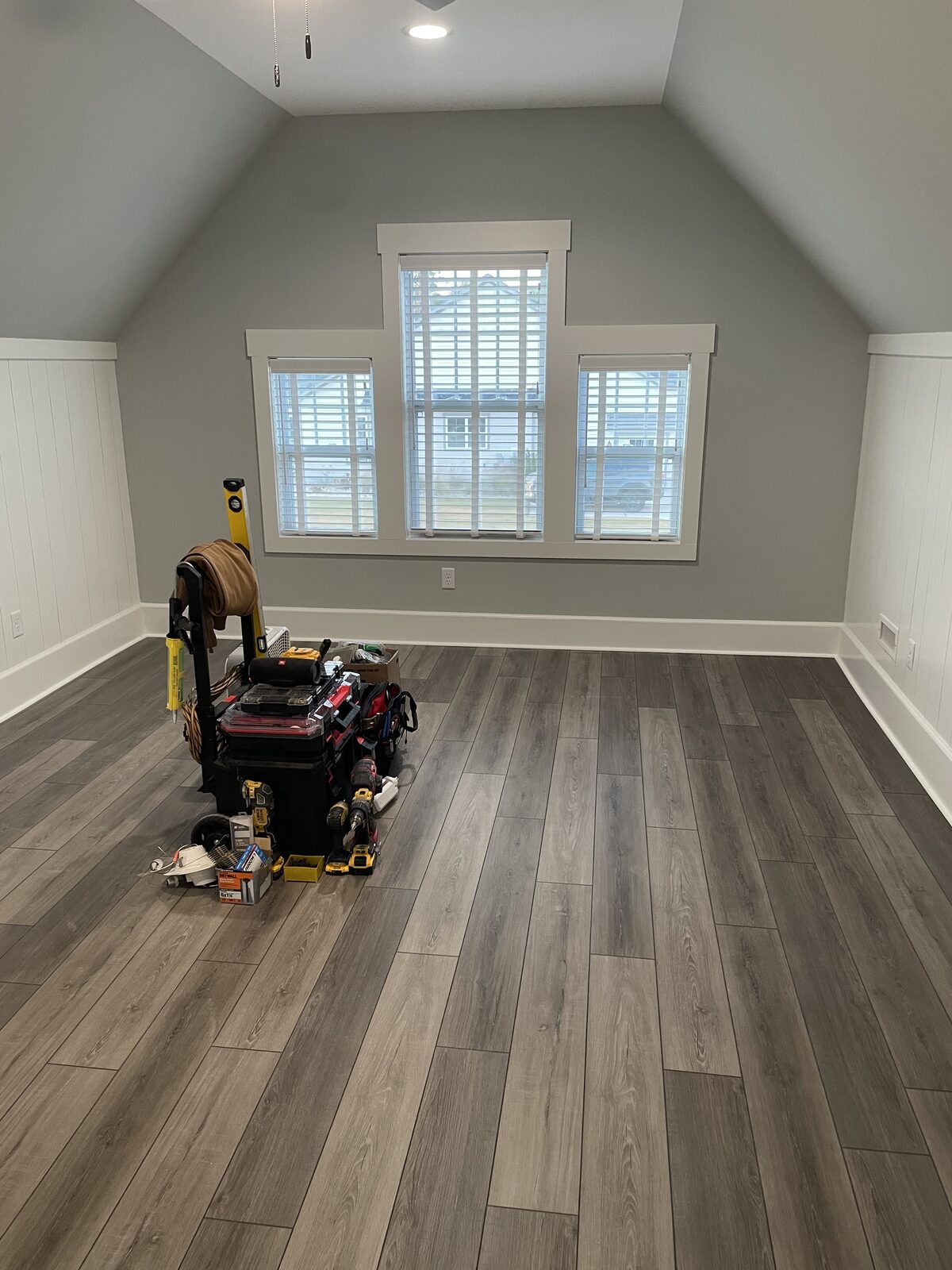 Finished room over a garage with windows and plank flooring